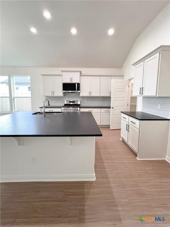 116 Raindance Ct, Victoria, TX 77904 - kitchen with appliances with stainless steel finishes, tasteful backsplash, dark countertops, recessed lighting, and lofted ceiling