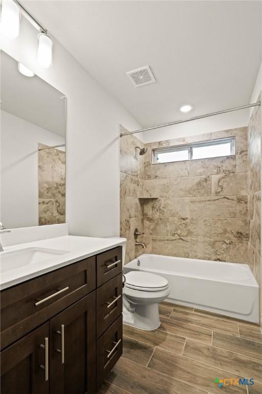 full bathroom featuring vanity, toilet, and tiled shower / bath combo