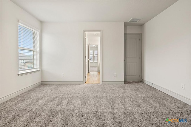 unfurnished bedroom featuring carpet flooring and ensuite bath