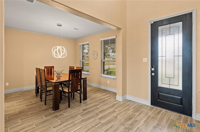 dining area featuring a notable chandelier, light hardwood / wood-style floors, and ornamental molding