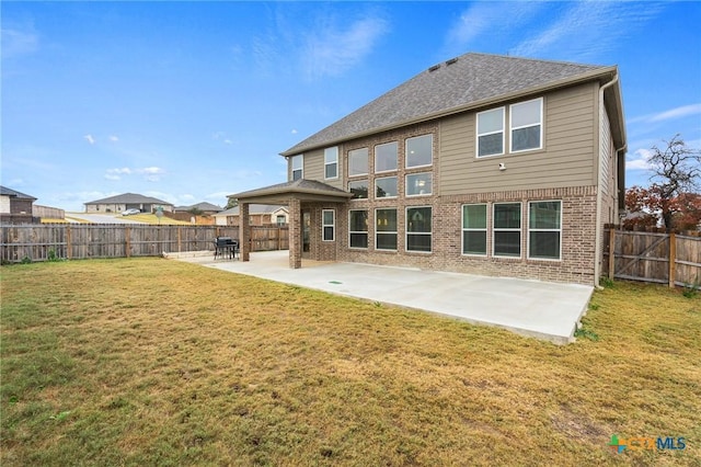 back of property featuring a yard and a patio