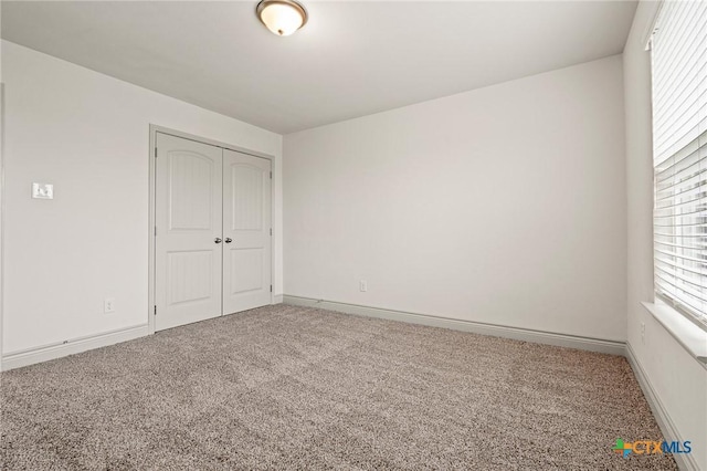 unfurnished bedroom featuring carpet flooring and a closet