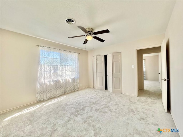 unfurnished bedroom featuring carpet, visible vents, a closet, and baseboards