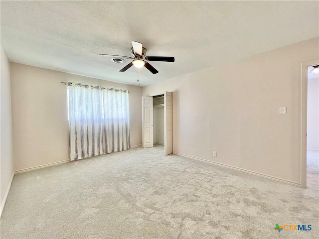 unfurnished bedroom featuring a ceiling fan, baseboards, a textured ceiling, and carpet flooring