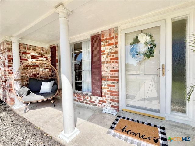 property entrance with brick siding and covered porch