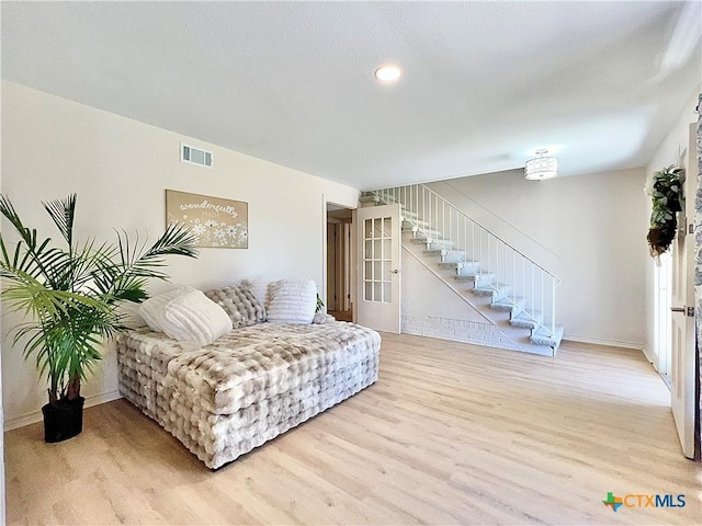 sitting room featuring stairs, wood finished floors, visible vents, and baseboards