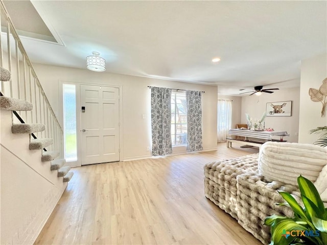 entryway with stairway, baseboards, and light wood-style floors