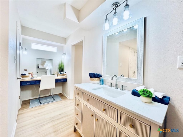 bathroom featuring vanity, baseboards, and wood finished floors