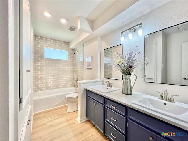 full bathroom featuring visible vents, wood finished floors, bathing tub / shower combination, and a sink