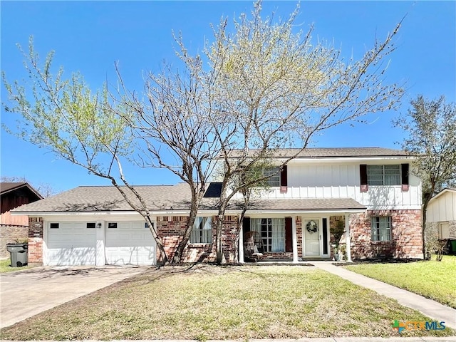 traditional home featuring brick siding, an attached garage, concrete driveway, and a front lawn