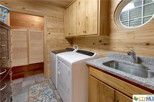 403 Bay St, Austwell, TX 77950 - laundry room featuring cabinets, separate washer and dryer, wood walls, and sink