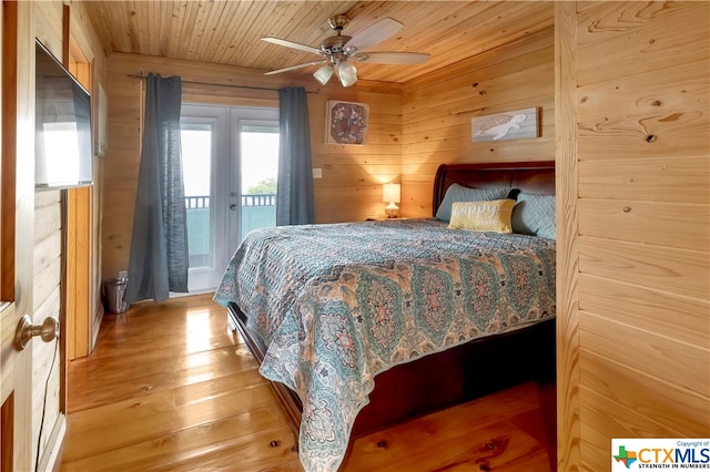 403 Bay St, Austwell, TX 77950 - bedroom with access to outside, wooden walls, wood ceiling, ceiling fan, and light hardwood / wood-style flooring