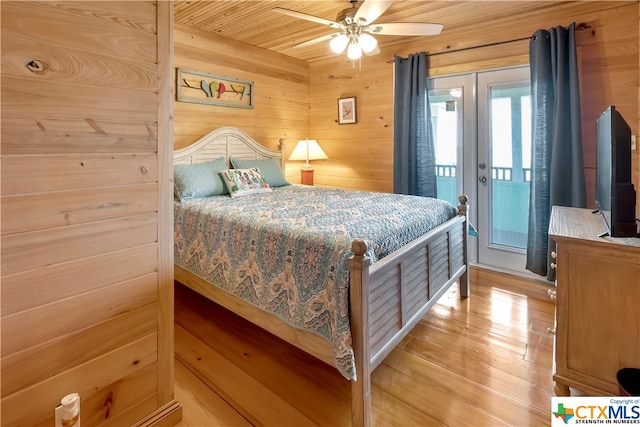 403 Bay St, Austwell, TX 77950 - bedroom with ceiling fan, wood ceiling, wooden walls, light wood-type flooring, and access to outside
