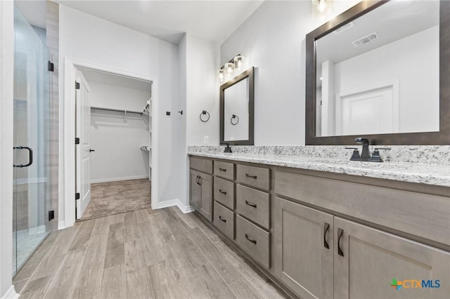 bathroom featuring vanity and a shower with shower door