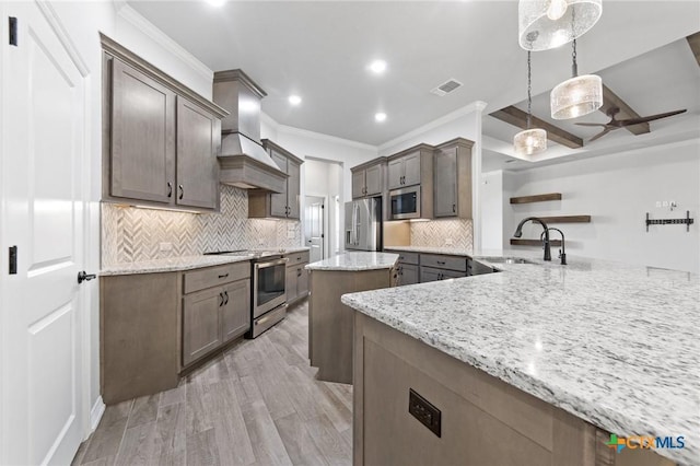 kitchen with kitchen peninsula, light stone countertops, stainless steel appliances, sink, and pendant lighting