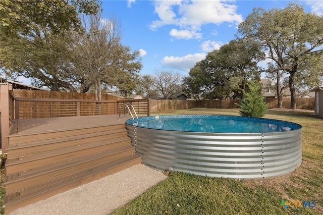 view of swimming pool featuring a yard and a deck