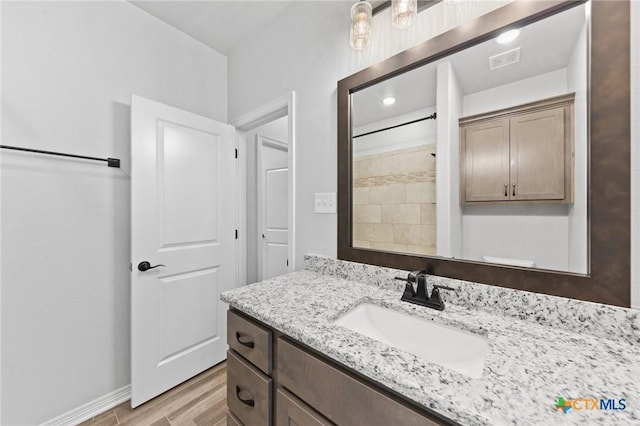 bathroom featuring hardwood / wood-style floors, vanity, and walk in shower