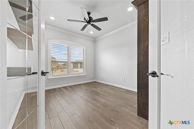 empty room featuring ceiling fan, wood-type flooring, and crown molding