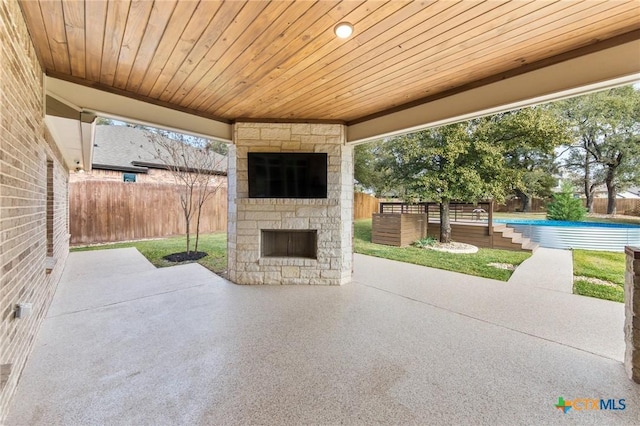 view of patio featuring a fenced in pool and an outdoor stone fireplace