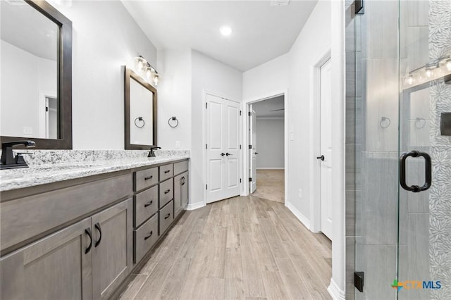 bathroom with vanity, wood-type flooring, and an enclosed shower