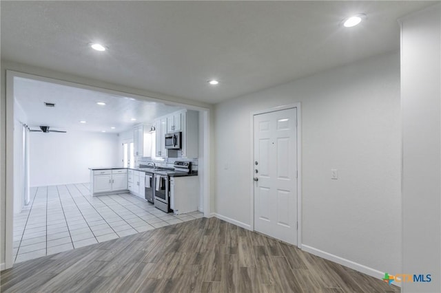 kitchen with stainless steel appliances, recessed lighting, white cabinetry, and light wood-style floors