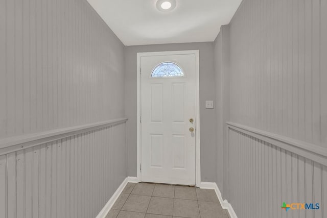 doorway featuring light tile patterned flooring and baseboards