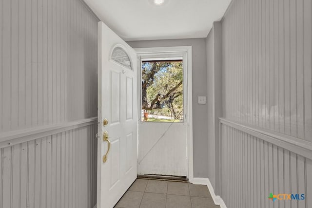 doorway to outside with light tile patterned floors and baseboards