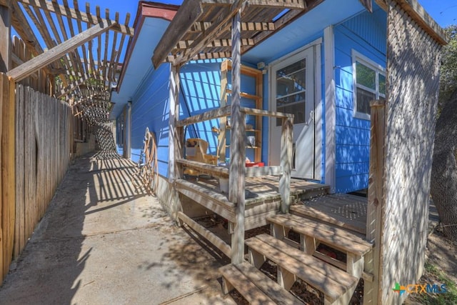 entrance to property featuring fence and a pergola