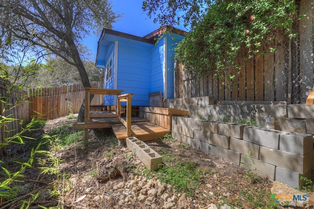 back of property with fence and a wooden deck