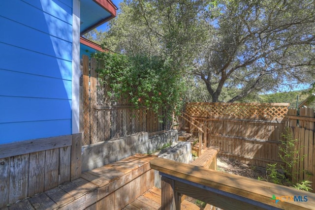 wooden terrace featuring fence