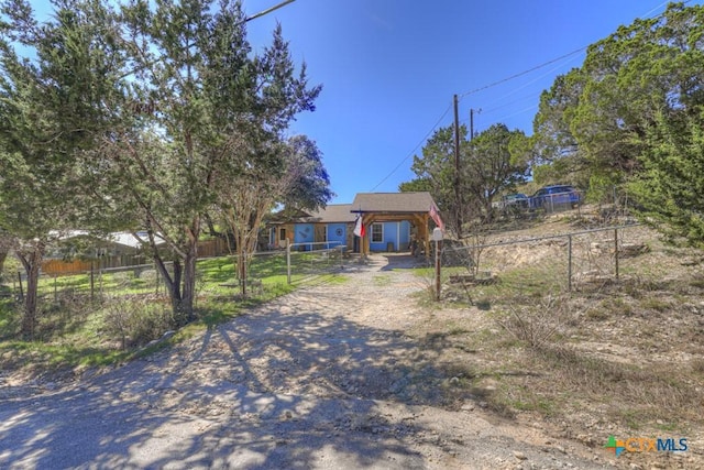 view of front facade featuring fence and driveway