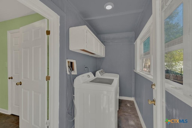 clothes washing area with cabinet space, independent washer and dryer, and baseboards