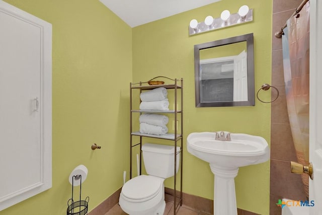 full bath featuring tile patterned flooring, baseboards, toilet, and curtained shower