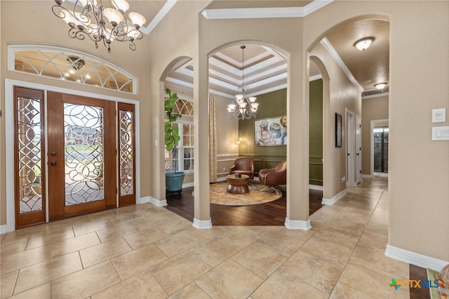 entrance foyer with a high ceiling, a chandelier, and crown molding