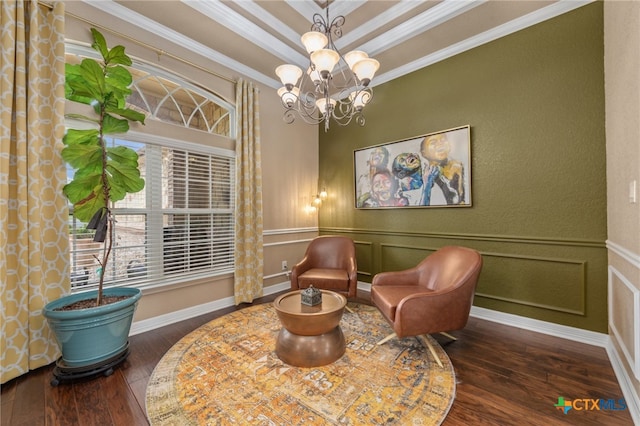 living area featuring dark hardwood / wood-style floors, a raised ceiling, an inviting chandelier, and crown molding