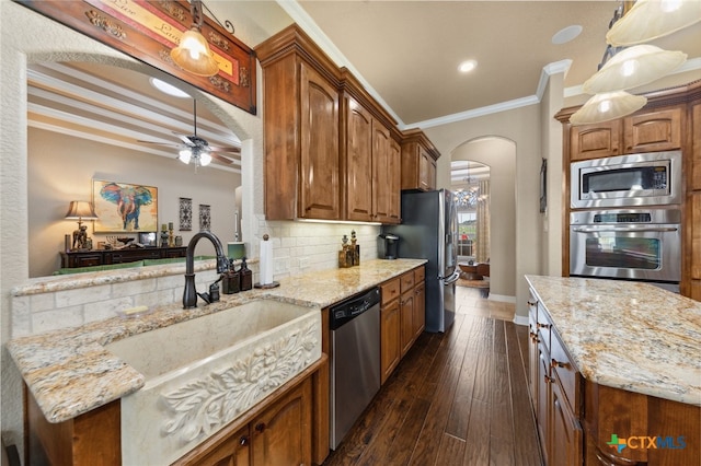 kitchen with stainless steel appliances, ornamental molding, dark hardwood / wood-style floors, backsplash, and light stone countertops