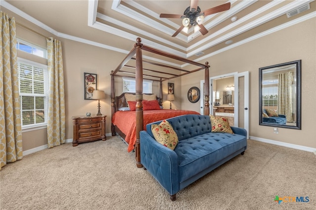 carpeted bedroom featuring ensuite bathroom, ceiling fan, a tray ceiling, and ornamental molding