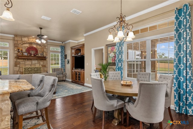 dining room with a healthy amount of sunlight, ornamental molding, and dark hardwood / wood-style floors