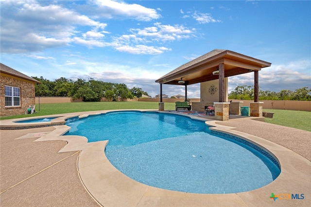 view of swimming pool with a patio area, a yard, and an in ground hot tub