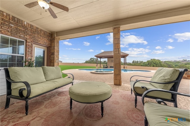 view of patio / terrace with ceiling fan and a pool with hot tub