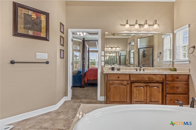 bathroom with tile patterned flooring, vanity, and a tub to relax in