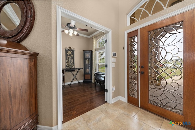 foyer featuring ceiling fan, light wood-type flooring, and ornamental molding