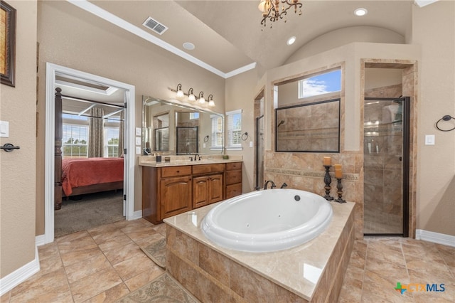 bathroom with vanity, independent shower and bath, a chandelier, and a healthy amount of sunlight