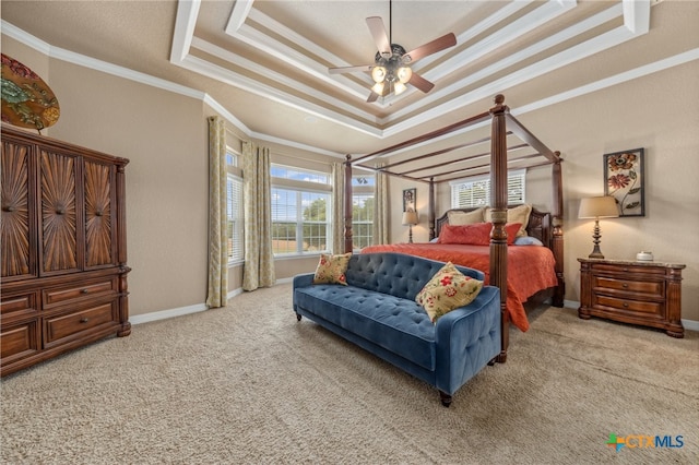 carpeted bedroom featuring ornamental molding, ceiling fan, and a tray ceiling