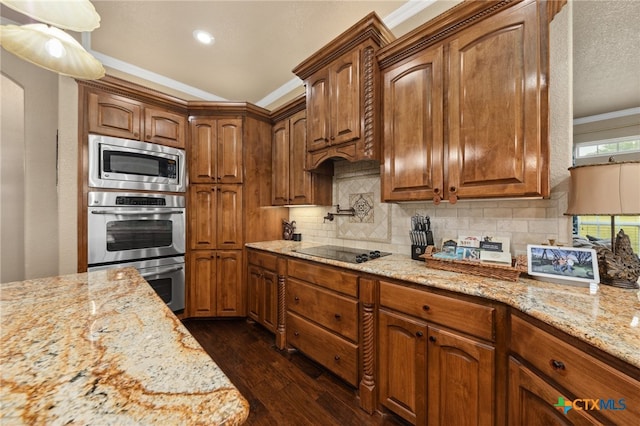 kitchen featuring dark hardwood / wood-style flooring, black electric cooktop, stainless steel microwave, ornamental molding, and light stone countertops