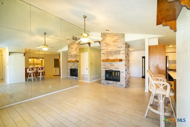 unfurnished living room featuring ceiling fan, a fireplace, and lofted ceiling