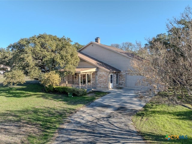 view of front of home with a front yard, covered porch, and a garage