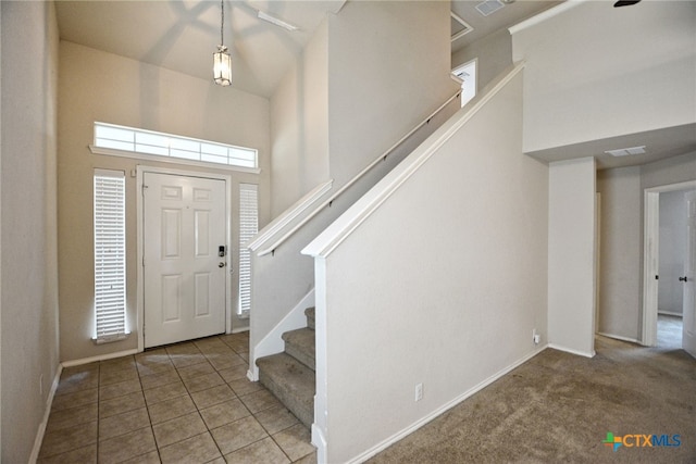 entrance foyer with a high ceiling and carpet