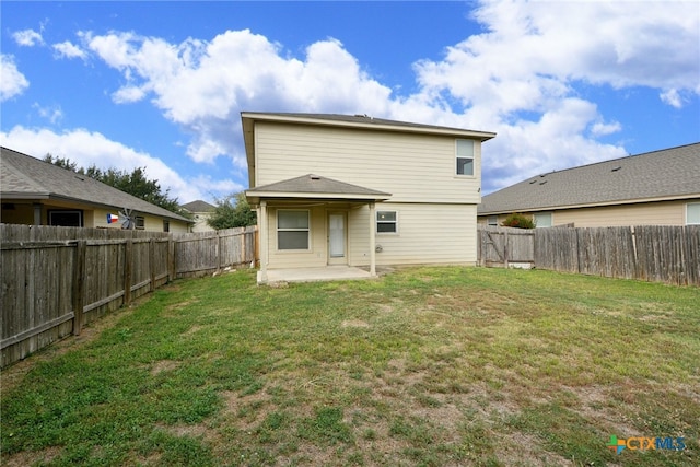 back of property featuring a patio and a yard