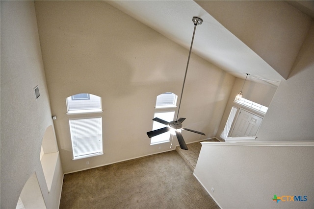 spare room featuring high vaulted ceiling, light carpet, and ceiling fan